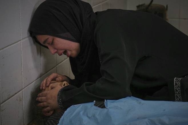 사라 알누리라는 팔레스타인 여성이 10일(현지 시간) 가자지구 데이르 알발라에 있는 '프로젝트 호프'(Project Hope)' 클리닉 앞에서 영양 보충제를 받으려다 이스라엘군의 공습으로 숨진 13세 동생 사마의 시신을 어루만지며 오열하고 있다. 이날 이스라엘의 공습으로 어린이 포함, 팔레스타인 주민 15명이 숨졌다. /AP=뉴시스