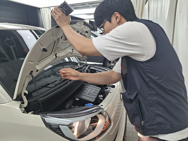 엔카 진단 검수팀 직원이 차량의 엔진룸을 체크하고 있다. [김성우 기자]