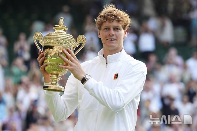 [런던=AP/뉴시스] 얀니크 신네르(1위·이탈리아)가 13일(현지 시간) 영국 런던 올잉글랜드 클럽에서 열린 2025 윔블던 테니스 대회 남자 단식 정상에 올라 트로피를 들고 포즈를 취하고 있다. 신네르는 결승에서 3연패를 노리는 카를로스 알카라스(2위·스페인)에게 3-1(4-6 6-4 6-4 6-4) 역전승을 거두고 윔블던 첫 우승을 차지했다. 2025.07.14.