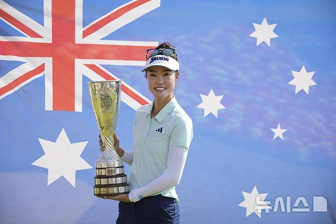 [에비앙=AP/뉴시스] 호주 교포 그레이스 킴이 13일(현지 시간) 프랑스 에비앙에서 열린 미국여자프로골프(LPGA) 투어 아문디 에비앙 챔피언십 정상에 올라 트로피를 들고 기념 촬영하고 있다. 그레이스 킴은 최종 합계 14언더파 270타로 지노 티티쿨(태국)과 동타를 이뤄 연장 끝에 우승을 차지했다. 2025.07.14.