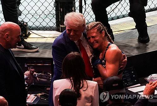 트럼프 미국 대통령에게 안겨 있는 UFC 챔피언 해리슨 [로이터=연합뉴스 제공]