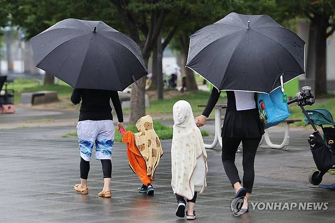 13일 서울 여의도물빛광장에서 물놀이를 즐기던 시민들이 비를 피해 이동하고 있다. [연합뉴스 자료사진]