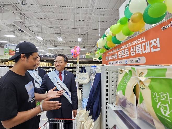 ▲ 지난 14일(현지시각) 캐나다 토론토에 있는 한인 마트인 갤러리아 슈퍼마켓 욕밀점에 방문한 유정복 인천시장이 인천산 농수산식품 상설 매대에 진열된 강화섬쌀을 살펴보는 손님과 대화를 나누고 있다.