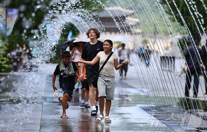 폭염이 이어지고 있는 9일 서울 종로구 광화문광장을 찾은 관광객이 바닥분수에서 더위를 식히고 있다. 2025.7.9/뉴스1 ⓒ News1 김도우 기자