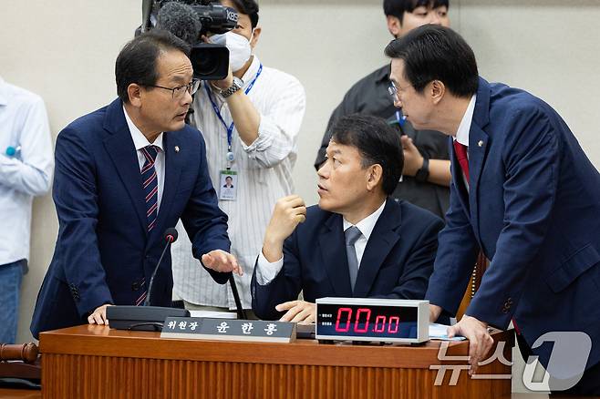 윤한홍 국회 정무위원장(가운데)과 더불어민주당 강준현, 국민의힘 강민국 간사가 15일 서울 여의도 국회에서 열린 권오을 국가보훈부 장관 후보자에 대한 인사청문회에 앞서 논의하고 있다. 2025.7.15/뉴스1 ⓒ News1 유승관 기자