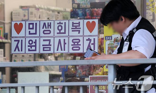 행정안전부가 민생회복 소비쿠폰 신청을 앞두고 국민비서를 통해 지급금액과 신청방법 등 정보를 사전 안내하는 서비스를 14일부터 시작한다.  사진은 13일 서울 시내 한 편의점에 게시된 민생회복 지원금 사용 관련 안내문. 2025.7.13/뉴스1 ⓒ News1 김성진 기자