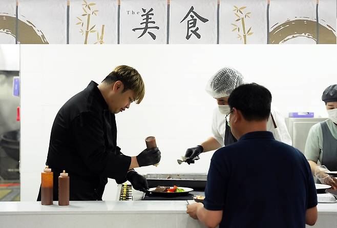 지난 11일 원익IPS 구내식당을 찾은 윤남노 쉐프. 윤 셰프가 조리부터 배식까지 했다. 이는 급식 위탁운영사 CJ프레시웨이가 펼치는 급식 캠페인 ‘더 미식 테이블’의 일환이다. /CJ프레시웨이 제공