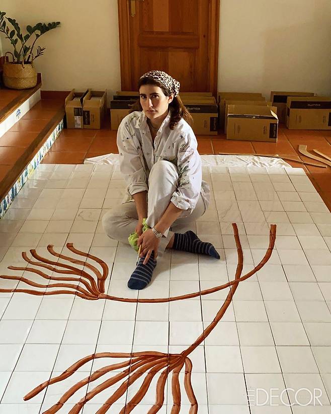 자신의 욕실을 위해 타일 조각을 맞추고 그 위에 그림을 그리고 있는 히셀라 탈리타.