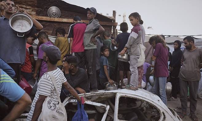 14일(현지시각) 가자 북부 가자시에서 주민들이 식량 배급을 기다리고 있다. 가자시/AP 연합뉴스