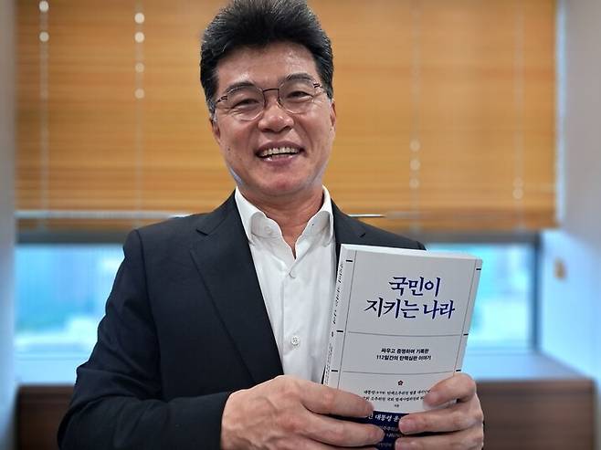 윤석열 탄핵소추 법률대리인단의 실무총괄을 맡았던 김진한 변호사가 14일 오후 서울 종로구 법무법인 클라스한결 회의실에서 최근 출간한 책 ‘국민이 지키는 나라’를 들고 포즈를 취하고 있다. 고경태 기자