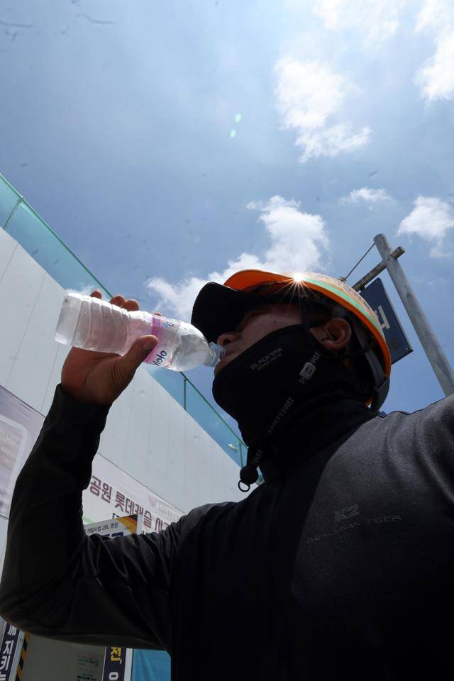 엿새째 폭염특보가 내려졌던 지난 2일 광주 서구 금호동 한 공사장 앞에서 건설노동자가 더위를 식히기 위해 물을 마시고 있다. 연합뉴스