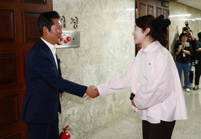 더불어민주당 당대표 출마를 선언한 정청래(왼쪽) 의원이 지난달 24일 서울 여의도 국회의사당에서 열린 의원총회를 앞두고 강선우 여성가족부 장관 후보자와 악수하고 있다. 뉴스1