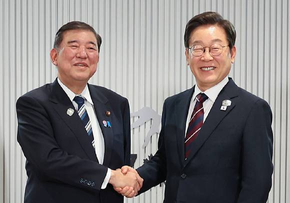 이재명 대통령이 지난달 17일 캐나다 앨버타주 캐내내스키스 주요 7개국(G7) 정상회의장에서 열린 한일 정상회담에서 이시바 시게루 일본 총리와 악수하며 기념촬영을 하고 있다. [사진=연합뉴스]