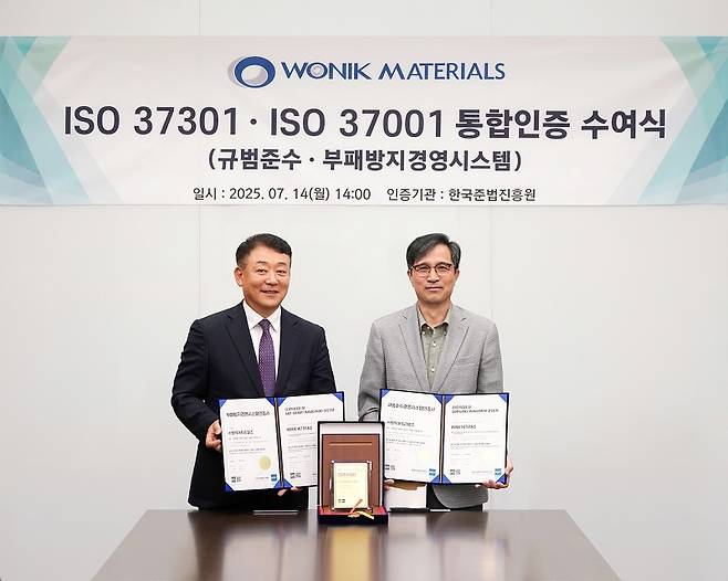 원익머트리얼즈 한정욱 대표(오른쪽)가 한국준법진흥원 이정명 원장으로부터 인증서를 받은 후 기념촬영을 하고 있다.