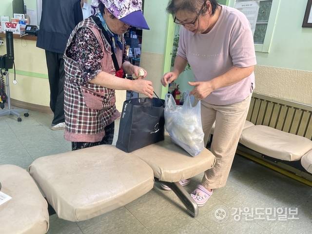 ▲ 지난 2023년 9월 본지와의 인터뷰 도중 지역 어르신이 옥수수를 나눠주기 위해 창촌의원을 방문한 모습. 고 윤성호 원장의 아내이자 간호사인 김미선(사진 오른쪽)씨 가 어르신과 안부를 나누고 있다. 유승현