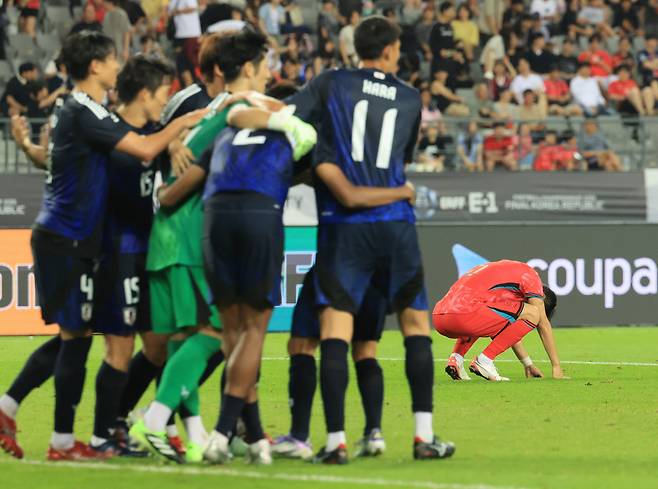 엇갈린 희비 한국 축구대표팀 박진섭(오른쪽)이 15일 경기 용인미르스타디움에서 열린 2025 동아시아축구연맹(EAFF) E-1 챔피언십(동아시안컵) 최종전에서 일본에 0-1로 패한 뒤 주저앉은 가운데 일본 선수들이 환호하고 있다. 용인 | 연합뉴스