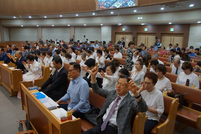 14일 부산 온천교회에서 열린 전국나라사랑기도총연합회 창립총회에서 참석자들이 두 손 들고 합심기도를 하고 있다.