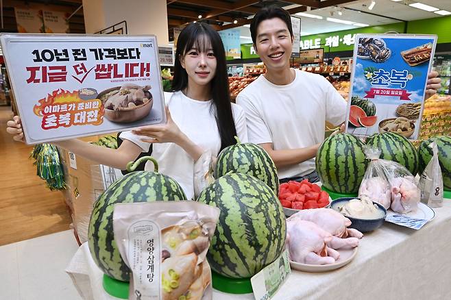모델들이 15일 서울 용산구 이마트 용산점에서 10년 전보다 싸게 파는 닭과 수박을 들어 보이고 있다. 윤웅 기자
