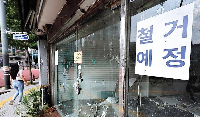 불황 장기화로 자영업자 폐업이 급증하고 있는 가운데 서울 시내의 한 폐업 점포 앞을 시민이 지나가고 있다.. 연합뉴스