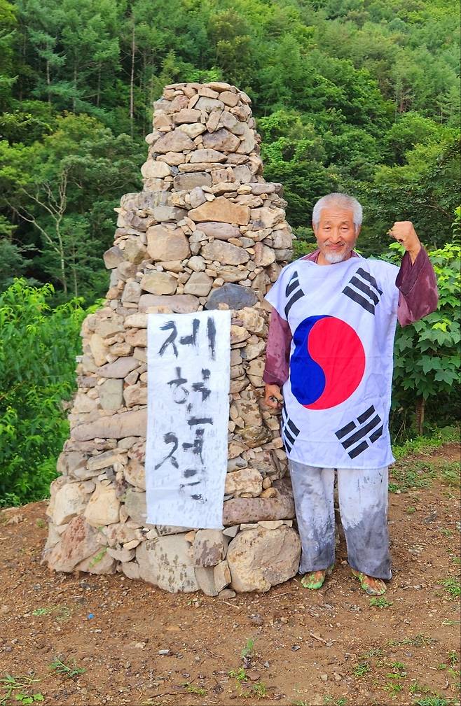 쌍산(雙산)은 15일 포항시 북구 기계면 인비리 암각화 공원에서 제77주년 제헌절을 기념해 자신의 몸에 태극기를 두른 퍼포먼스를 펼치고 있다.