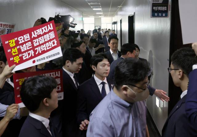 국민의힘 보좌관협의회 회원들이 피켓시위를 벌이자 강선우 여성가족부 장관 후보자가 보좌관들의 호위를 받으면서 14일 국회 인사청문회장으로 입장하고 있다. 조태형 기자