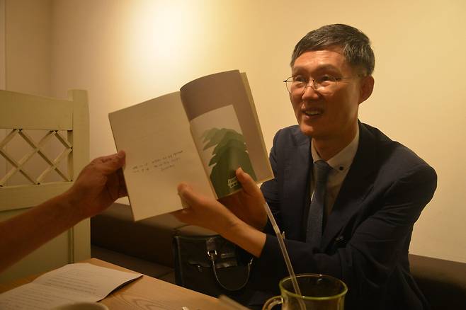 문형배 전 헌법재판관이 김장하 선생이 선물해준 책 <나무야 나무야>를 들어 펼쳐 보이고 있다. ⓒ김주완 제공
