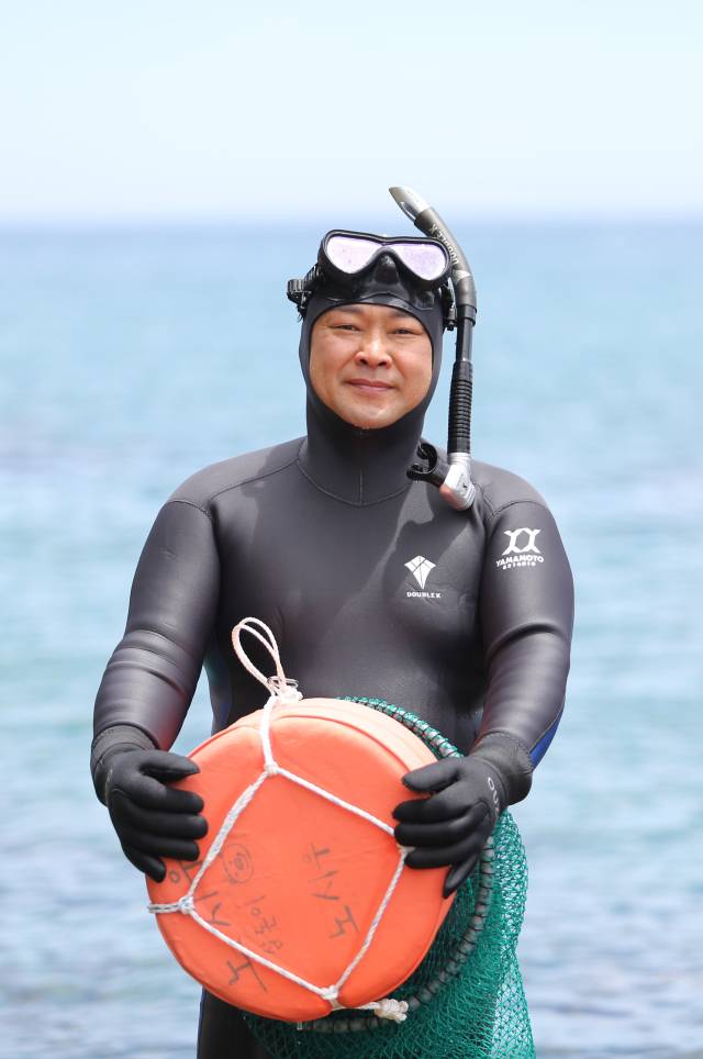 노시우 씨가 경북 울진군 북면 앞바다에서 자신이 직접 만든 테왁을 들고 포즈를 취하고 있다. 김도훈 기자