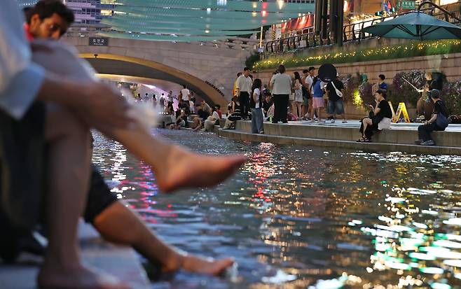 (서울=뉴스1) 장수영 기자 = 이른 폭염과 함께 열흘 넘게 열대야가 이어지고 있는 9일 저녁 서울 중구 청계천을 찾은 시민들이 더위를 식히고 있다. 2025.7.9/뉴스1