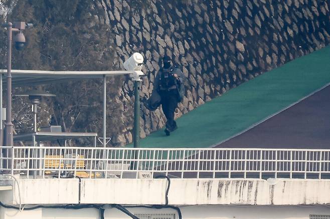 고위공직자범죄수사처의 윤석열 당시 대통령 2차 체포 영장 집행이 임박한 가운데 1월14일 오후 서울 용산구 대통령 관저에서 기다란 배낭을 맨 사람이 나가고 있다. 김영원 기자 forever@hani.co.kr