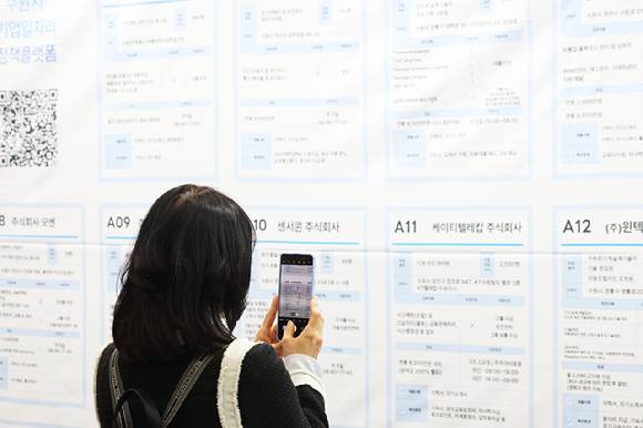 지난 4월 경기도 수원시 영통구 수원컨벤션센터에서 열린 '수원 일자리 박람회'에서 구직자가 채용 게시판을 휴대전화로 찍고 있다. [사진=연합뉴스]