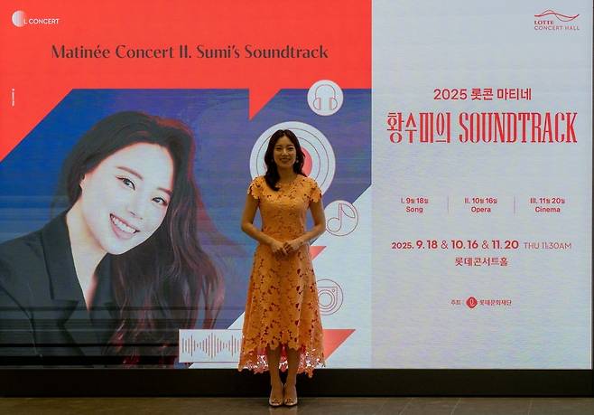 공연 홍보물 앞에 선 소프라노 황수미 /사진. 롯데문화재단 제공
