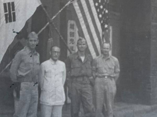 이범석 장군(왼쪽 두 번째)과 OSS 장교들이 태극기와 성조기를 배경으로 찍은 사진이다. 뒤에는 ‘한국광복(군)’으로 시작하는 현판이 보인다. 1945년 초에 촬영된 것으로 추측된다. 국사편찬위원회 제공