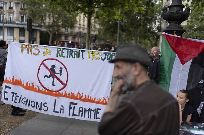 지난해 7월 25일(현지시각) 프랑스 파리의 리퍼블리크 광장에서 2024년 하계 올림픽 개막에 반대하는 여러 단체의 시위가 열린 가운데 "연금 없이 올림픽 없다" "성화를 꺼버리자"라고 쓰인 현수막이 걸려 있다./AP=뉴시스