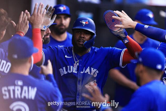 토론토의 블라디미르 게레로 주니어(가운데)가 득점을 한 뒤 더그아웃에서 동료들의 축하를 받고 있다. /게티이미지코리아
