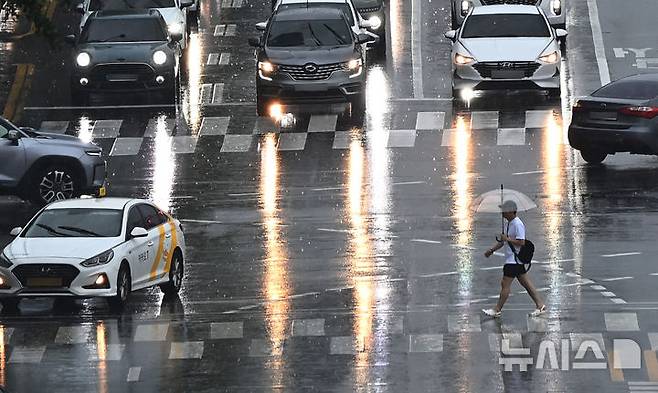 [수원=뉴시스] 김종택 기자 = 수도권 등 중부지역에 호우주의보가 발효된 16일 경기 수원시 팔달구 경수대로에서 한 시민이 우산을 쓰고 이동하고 있다. 2025.07.16. jtk@newsis.com