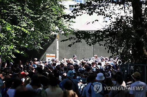 오아시스 팬들이 현지시간 11일 영국 맨체스터 히튼 파크 게이트 근처에 모여 있다. [로이터=연합뉴스]