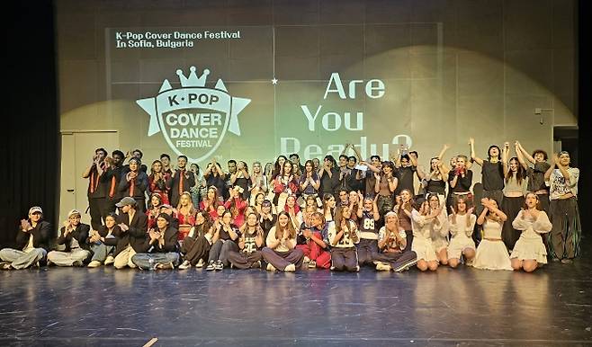 지난 12일(현지시간) 불가리아 수도 소피아 토플로센트랄라 문화센터에서 열린 ‘2025 K팝 커버댄스 페스티벌 인 불가리아’에 참가한 15개팀들이 경연을 마친 뒤 함께 기념촬영을 하고 있다.