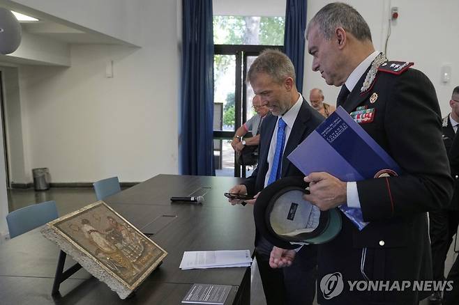 반환된 폼페이 모자이크 (폼페이 AP=연합뉴스) 15일(현지시간) 이탈리아 폼페이 고고학공원에서 고대 로마 시대 모자이크 반환식이 열린 가운데 가브리엘 추흐트리겔 소장(왼쪽)과 로마 카라비니에리 문화유산 보호 부대(TPC)의 프란체스코 가르가로 사령관이 작품을 감상하고 있다. 2025.07.15 photo@yna.co.kr