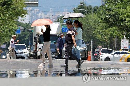 폭염에 아지랑이 피어오르는 도로 전국 대부분 지역에 폭염 특보가 발효된 7월 3일 광주 서구 치평동에서 시민들이 강렬한 햇빛에 달구어져 아지랑이가 피어오르는 도로를 걷고 있다. [연합뉴스 자료사진]