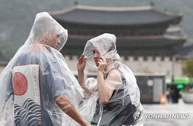 '우비 필수' (서울=연합뉴스) 김성민 기자 = 비가 내린 14일 서울 종로구 광화문광장 인근에서 외국인 관광객이 비를 맞으며 이동하고 있다. 2025.7.14 ksm7976@yna.co.kr