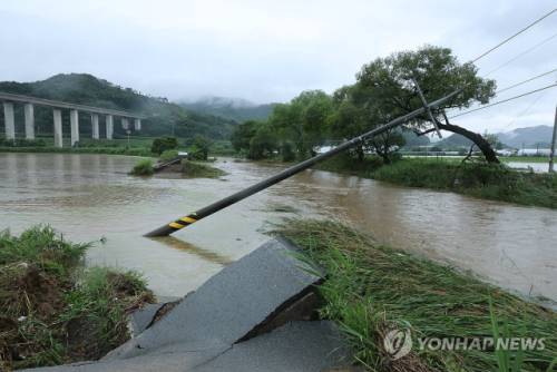 ◇17일 오후 호우특보가 내려진 충남 공주시 사곡면에서 한 도로가 무너져 내렸고 전봇대가 위태롭게 쓰러져 있다. 2025.7.17 사진=연합뉴스