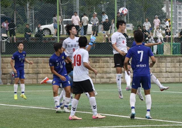 부산정보고와 경기 수원공고 선수들이 지난 16일 경남 고성군 스포츠파크 1구장에서 열린 제62회 청룡기 전국고교축구대회 조별리그 첫날 경기에서 공 다툼을 벌이고 있다. 부산시축구협회 제공