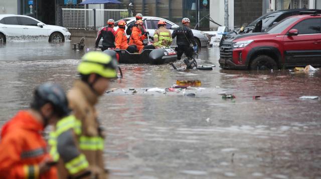 17일 오후 대구 북구 노곡동에서 119구조대가 보트를 타고 인명 수색을 하고 있다. 이날 갑작스러운 폭우로 노곡동 일대가 침수됐다. 연합뉴스