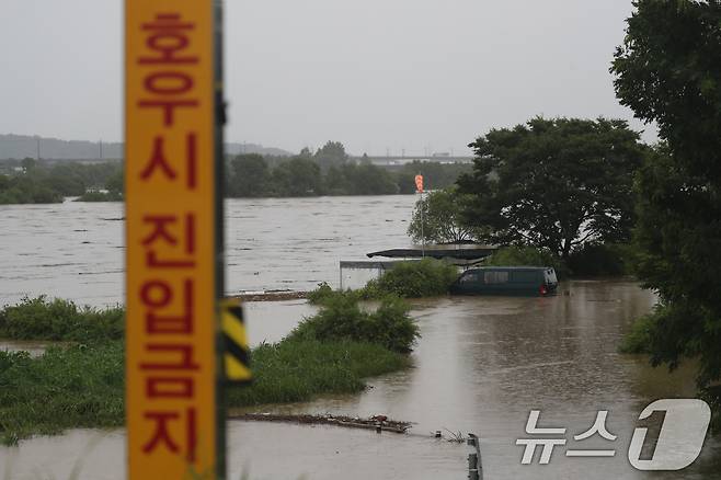 밤 사이 230mm가 넘는 폭우가 쏟아진 17일 충북 청주시 미호강변에 차량 한대가 침수돼 있다. 2025.7.17/뉴스1 ⓒ News1 김용빈 기자