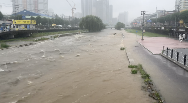 광주 양동시장 인근 광주천 산책로가 물에 잠겨 있다. 장대비가 쏟아진 17일 오전 급류가 인도 경계까지 차오르며 산책로는 통제됐다. 송보현 기자