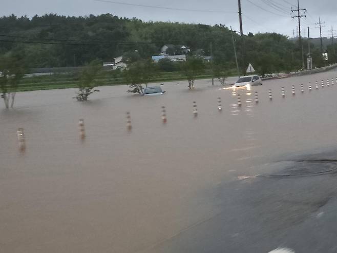 17일 오전 8시께 충남 서산시 성연면 이안큐브 앞 도로가 호우로 침수돼 차량이 물에 잠겨 있다.  2025.07.17. 독자 제공