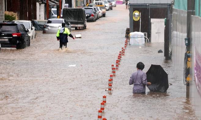 100㎜ 폭우가 쏟아진 17일 오전 광주광역시 남구 백운광장 인근 상가와 도로가 물에 잠겨 있다. 연합뉴스