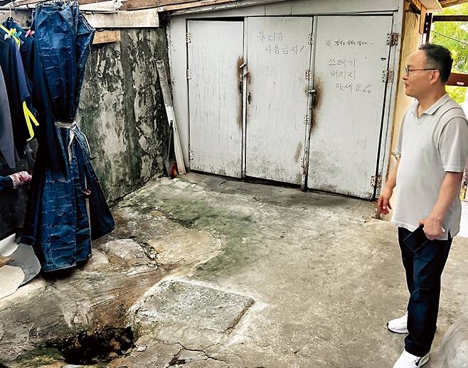 쪽방 주민들이 공동으로 사용하는 수돗가와 화장실을 전익형 서울역쪽방상담소 실장이 둘러보고 있다.