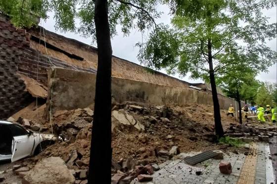 16일 오후 7시 4분쯤 경기 오산시 가장교차로 고가도로의 10ｍ 높이 옹벽이 도로로 무너지며 차량을 덮치는 사고가 발생해 소방대원들이 구조작업을 하고 있다. 사진 경기도소방재난본부