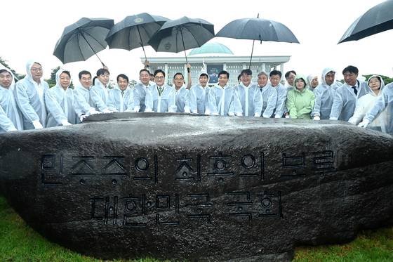 17일 오전 서울 여의도 국회 잔디광장에서 열린 국회 상징석 제막식에서 우원식 국회의장 등 참석자들이 기념촬영을 하고 있다. 상징석에는 국회가 민주주의의 보루로서 ‘12?3 비상계엄’ 해제를 이끌었다는 내용의 문구가 새겨져 있다. 국회사진기자단